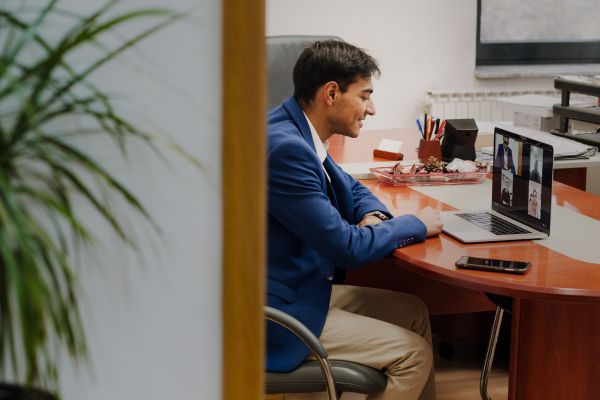 Public Health Professional in their office with their laptop talking during a group virtual meeting