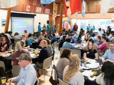 OHSU-PSU School of Public Health Students Attending the Fall Welcome. Graduate and Undergraduate Students Sitting at Tables discussing public health topics and lived experiences together