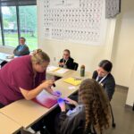 Rural Public Health Summer Camp Counselor teaching students about germ and bacteria spread by using a black light