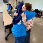 Rural Public Health Initiative Summer Camp Counselor hugging summer camp student